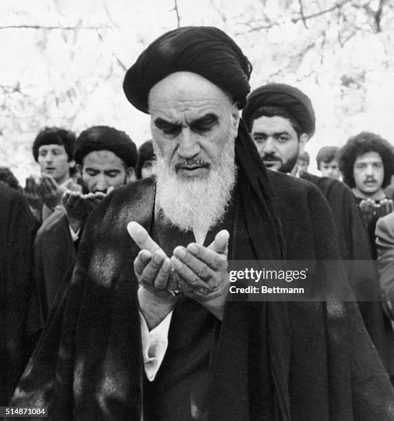 Ayatollah Ruhollah Khomeini prays in the garden of his villa in Pontchartrain, near Paris, where he is staying during his exile from Iran.