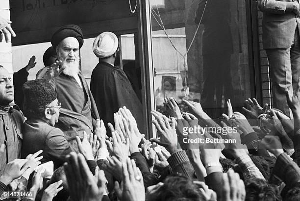 Ayatollah Khomeini waves to a crowd of supporters from the window of his Tehran home.