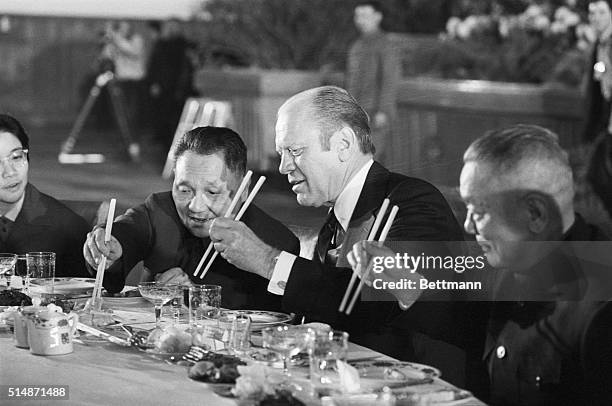 Peking, China: President Ford and Chinese Vice Premier Teng Hsiao-Ping reach for food with their chopsticks during the last banquet.