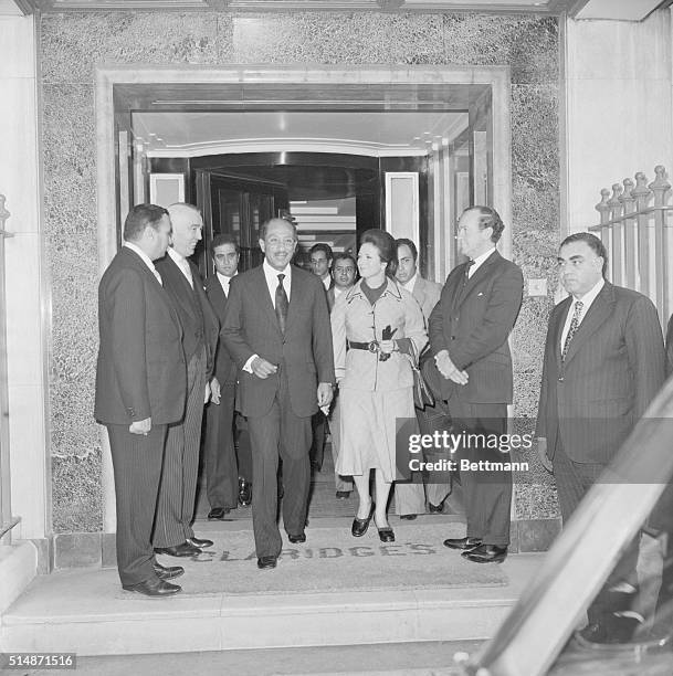 London, England: President Anwar Sadat of Egypt leaves Claridges Hotel, London 11/6, with his wife, to drive to Buckingham Palace for luncheon with...