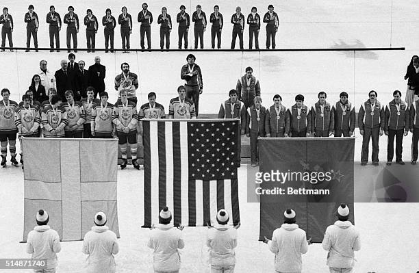 Lake Placid, NY: The medal-winning teams in the Olympic hockey competition line up for the singing of the national anthems during presentation...