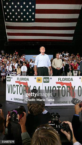 President George W. Bush looks on above photographers at a Florida Victory 2004 rally at Sound Advice Amphitheatre October 16, 2004 in West Palm...