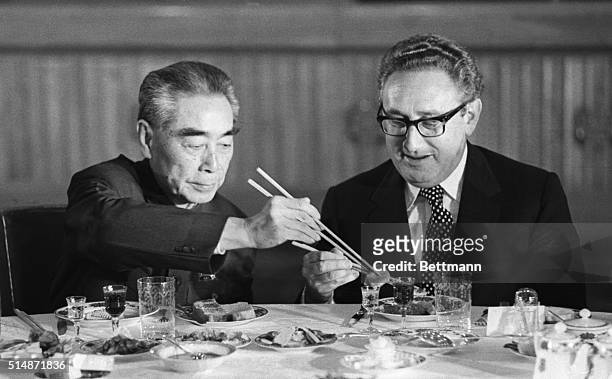 Secretary of State Henry Kissinger accepts food from Chinese Premier Zhou Enlai during a state banquet in the Great Hall of the People in Beijing.