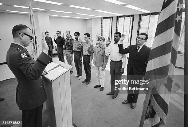 The induction office's executive officer Captain Robert Gallagher administers the oath, as those who have passed all the tests are inducted into the...