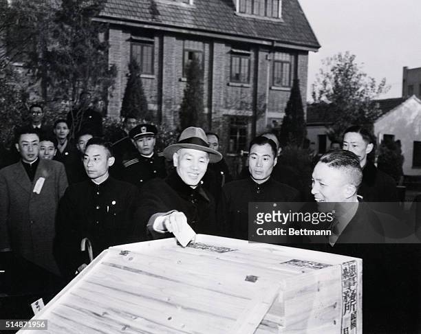 Nanking, China: President Chiang Kai-shek drops his ballot in the box after voting in the nationwide general election for members of the National...