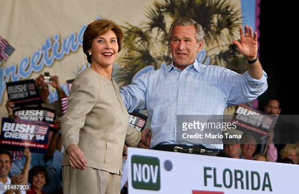 President George W. Bush and first lady Laura Bush wave to supporters at a Florida Victory 2004 rally at Sound Advice Amphitheatre October 16, 2004...