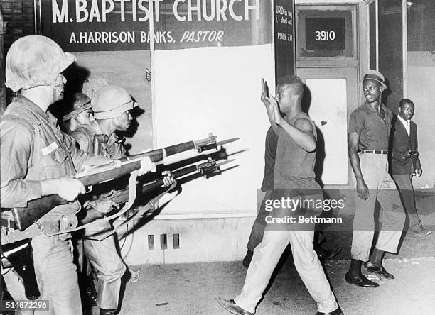 National Guard troops aim rifles with bayonets at rioters in Chicago on July 16, 1966.