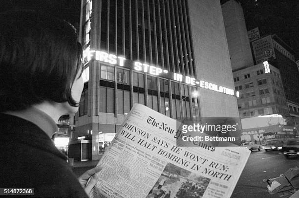 Woman reads the first page of the New York Times of Aril 1 when the headlines declared : "Johnson Says He Won't Run; Will Halt Bombing in North"....
