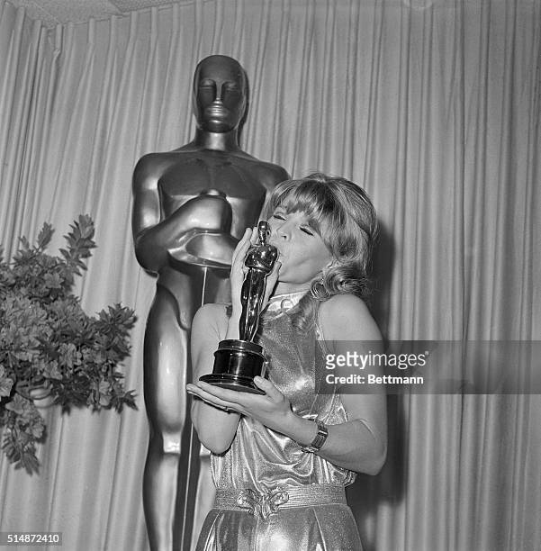 Actress Julie Christie kisses the Best Actress Oscar she won at the 38th Annual Academy Awards for her performance in the movie Darling.