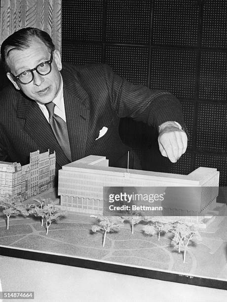 London, England: Finnish born architect Eero Saarinen points to features of a scale model of the new five story embassy in London's Grosvenor Square....