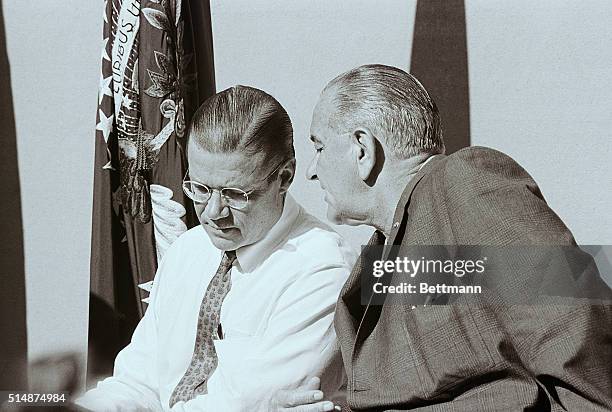President Lyndon Johnson whispers to Defense Secretary Robert McNamara during a news conference at Johnson's ranch in Texas. Johnson is resting at...