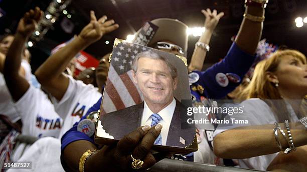 Supporters of U.S. President George W. Bush hold up four fingers while chanting "Four More Years" inside the Office Depot Center during a Florida...