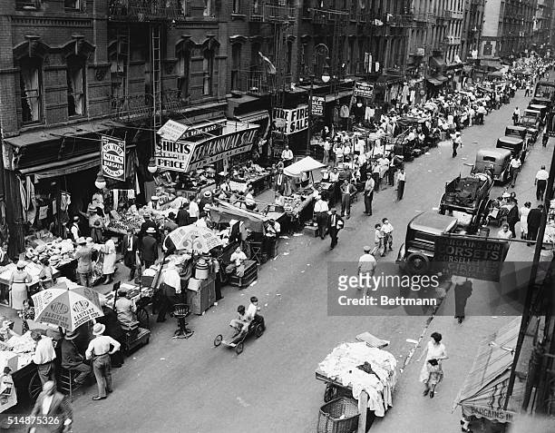 Vendors sell their wares from pushcarts on a street in New York's lower east side, 1932.