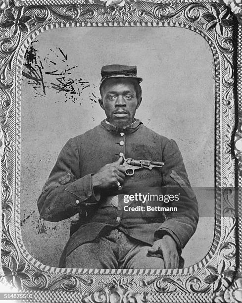 Portrait of an unidentified Union Infantry corporal, holding a Colt model 1849 pocket revolver. Civil War camp photographers kept such equipment to...