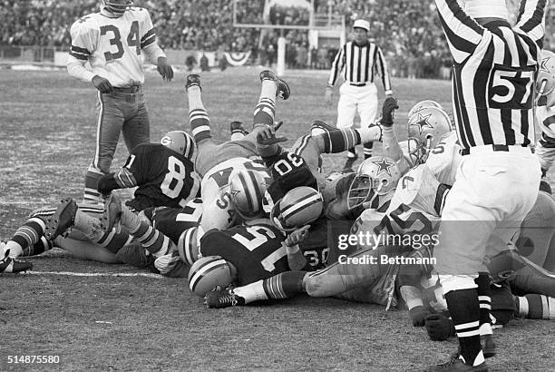 Official signals touchdown as Packers' Bart Starr plunges for line for winning TD in 4th qtr. Of NFL Championship game with Dallas. December 31, 1967.