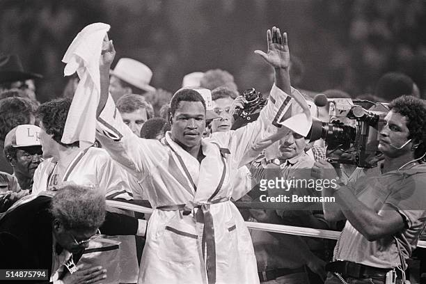 Heavyweight champion Larry Holmes raises his arms in victory after knocking out challenger Leon Spinks in a 1981 bout.