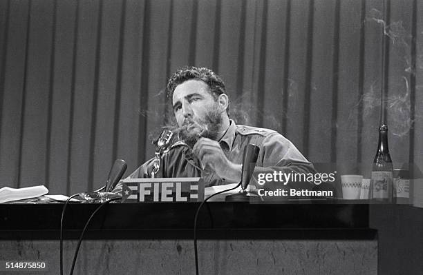 Fidel Castro lights a cigar during a meeting.