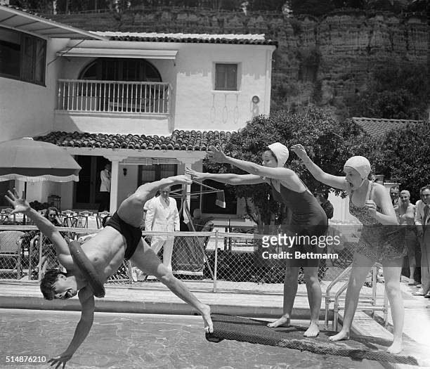 Santa Monica, CA: Film Comedian Micky Rooney is going overboard with the help of actresses Ann Rutherford and Judy Garland during a frolic at Judy's...