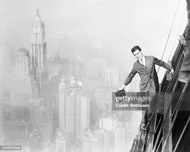 New York, NY: Jack Reilly, intrepid photographer, precariously perched from the 72 story of the world's tallest building, the 74 story Bank of...