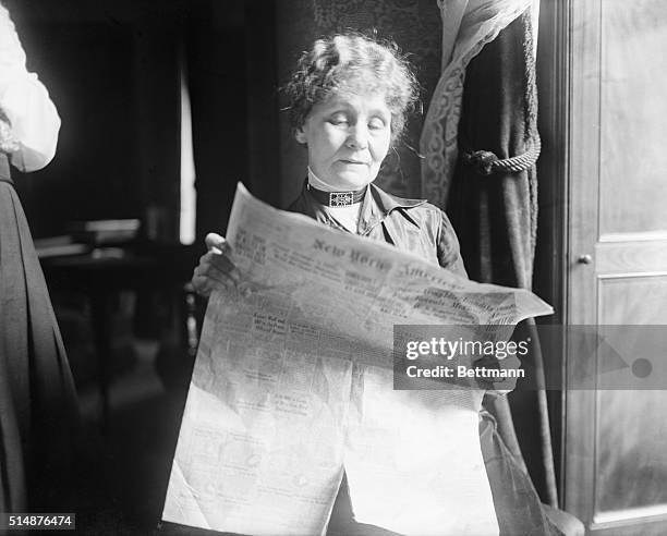 Mrs. Emmeline Pankhurst, English suffragist, in her Manhattan Hotel Apt, reading the New York American newspaper.