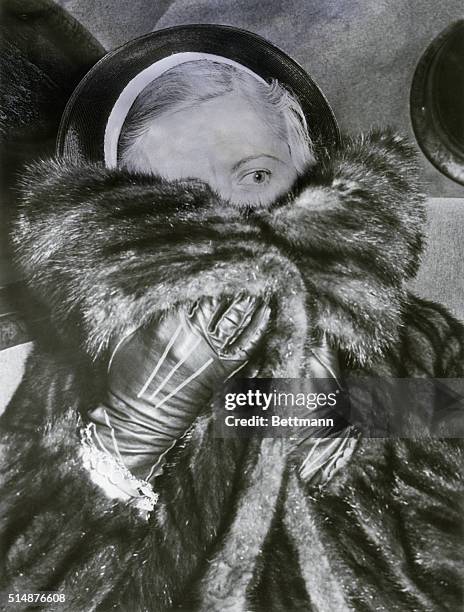 Seldom photographed, Al Capone's wife, Mae, tries to avoid photographers after a visit to see her racketeer husband in December, 1937. According to...