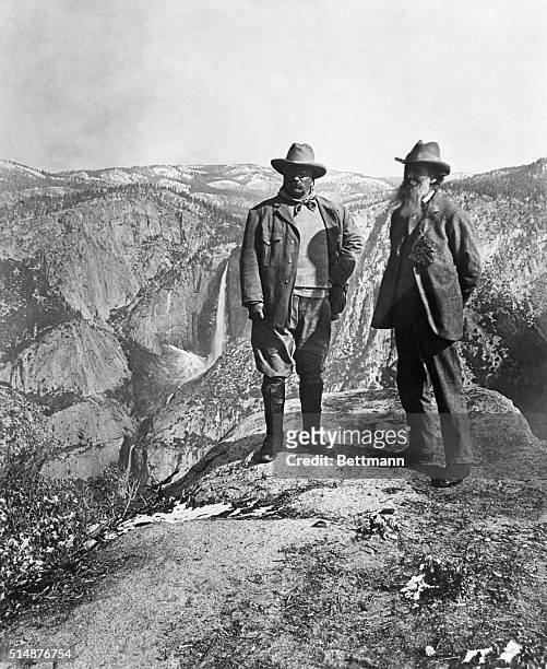 Theodore Roosevelt stands with naturalist John Muir on Glacier Point, above Yosemite Valley, California, USA.