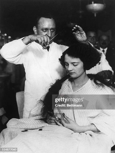 New York: Miss Muriel Redd of Chicago, appearing in show "Tickle Me" having her hair bobbed by Barber Lewis Morgan, Mgr., at the Hotel McAlpin Barber...