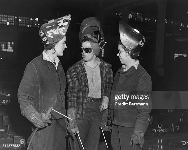 Woman swing shifters interrupting their work as welders at Bethlehem Steel Shipyard for chat. World War II photograph.