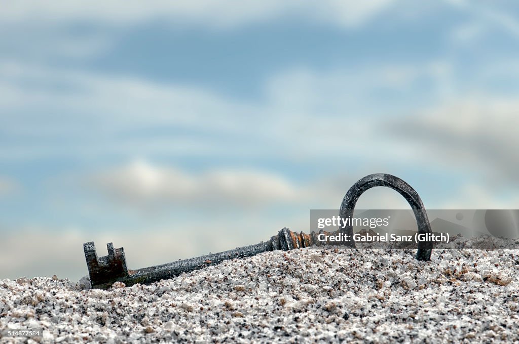 Old key in the sand