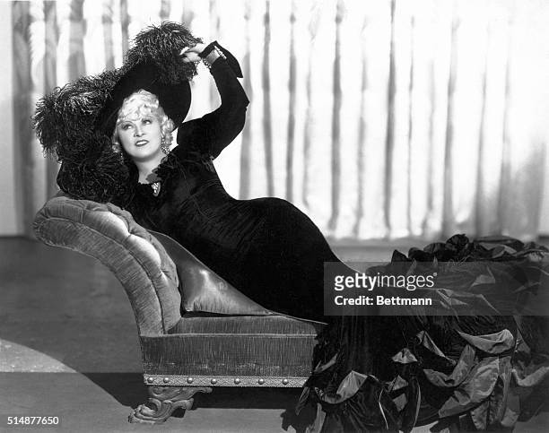 American actress Mae West reclining on a chaise longue in a promotional portrait for 'Klondike Annie', directed by Raoul Walsh, 1936. West was...