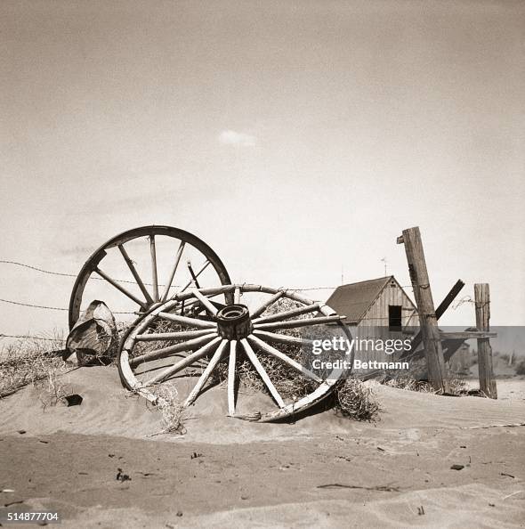 Wagon Wheels Leaning Against Barbwire Fence