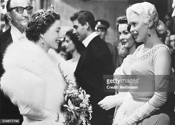 London, England: American actress Jayne Mansfield and England's Queen Elizabeth II are shown chatting on the reception line during the Royal Command...