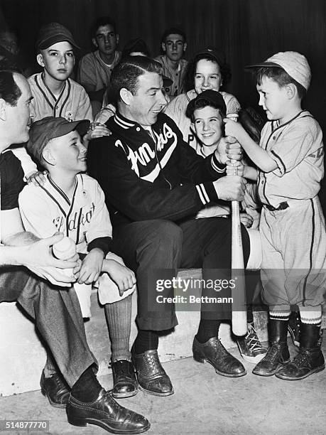 Joe DiMaggio with Little League baseball players of Edgewater, New Mexico. Kevin Walsh mascot of Edgewater P.A.L. Team holds bat with him.