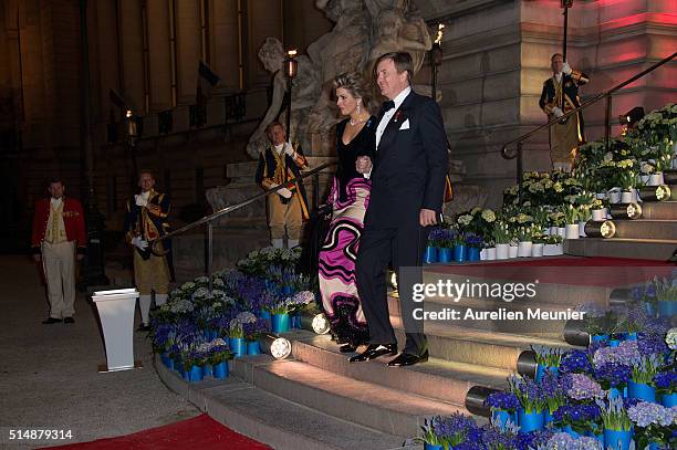 King Willem-Alexander of the Netherlands and Queen Maxima are walking down the stairs to welcome French President Francois Hollande to a reception...