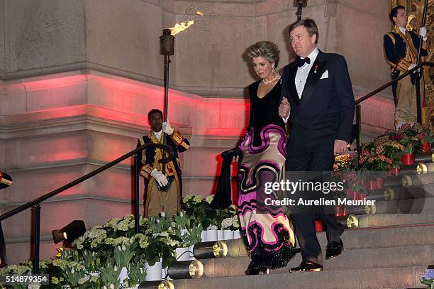 King Willem-Alexander of the Netherlands and Queen Maxima are walking down the stairs to welcome French President Francois Hollande to a reception...