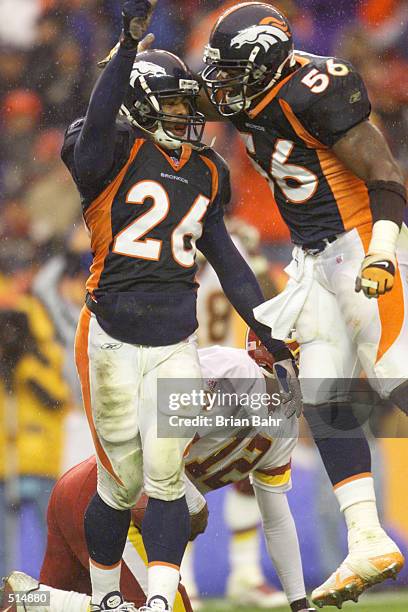 Eric Brown and Al Wilson of the Denver Broncos celebrate a sack on quarterback Tony Banks of the Washington Redskins during the game at Mile High...