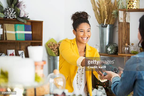 vendedora ayudando a cliente - happy merchant fotografías e imágenes de stock