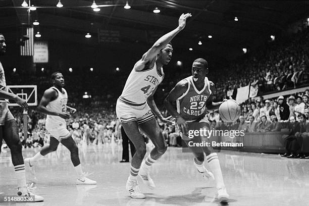 University of North Carolina guard Michael Jordan wags his tongue as he dribbles the basketball past a North Carolina State defender. January 13,...