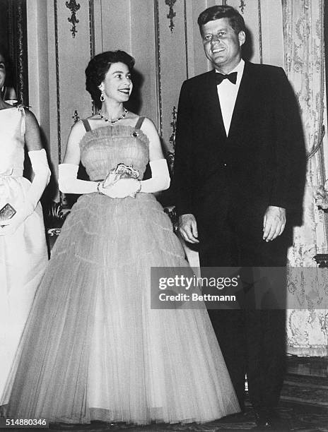 Queen Elizabeth smiles at President John F. Kennedy during a state dinner at Buckingham Palace.