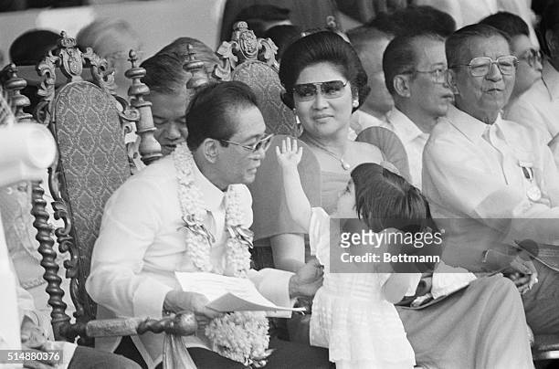 Philippines President Ferdinand Marcos and his wife Imelda play with their three-year-old niece Aimee while presiding over Independence Day...