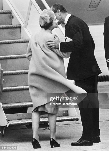 In Ottawa, Prince Philip kisses Queen Elizabeth before she boards a plane for London.