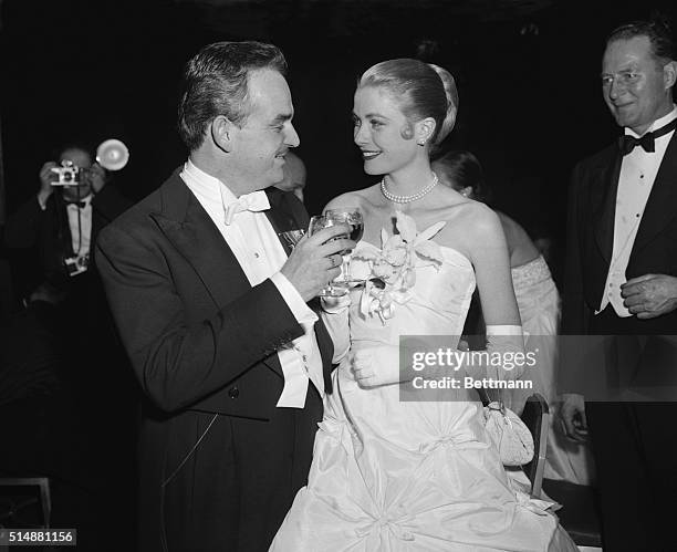 New York: Lovely screen actress Grace Kelly and her fiance Prince Rainier III of Monaco, toast each other during "Imperial Ball" at the...