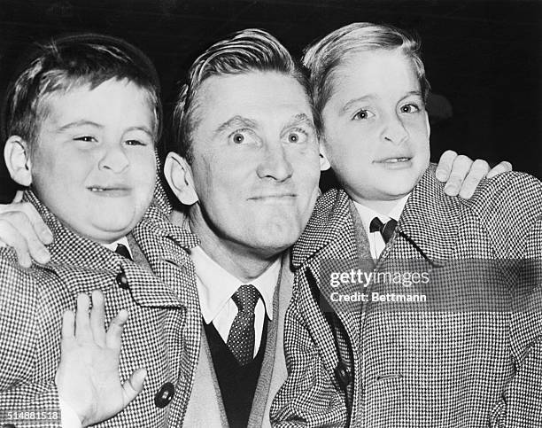 Idlewild Airport, New York: Joel Douglas, left and Michael Kirk right, make funny faces for the cameraman with noses pressed against the glass of the...