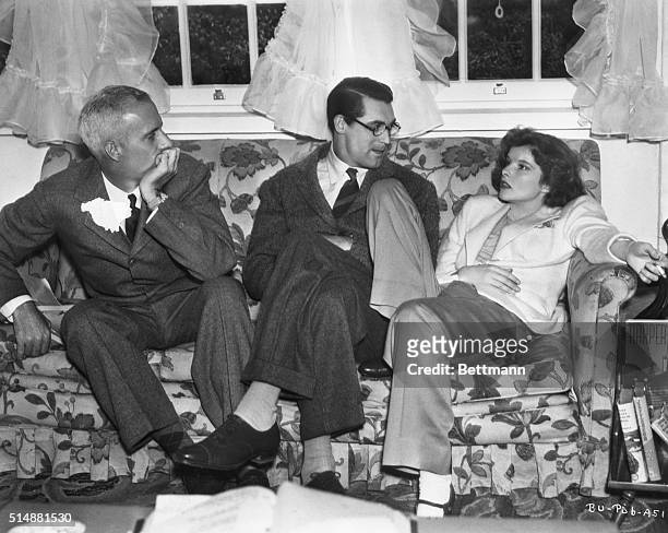 Director Howard Hawks and stars Cary Grant and Katharine Hepburn sit on a sofa during the filming of Bringing Up Baby.