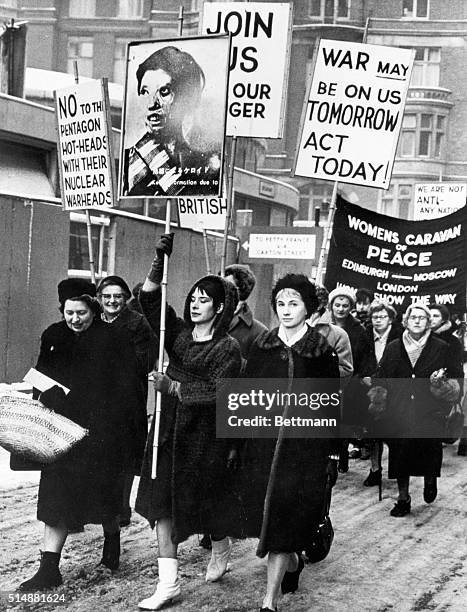 London, England: Heading a procession of women on an anti-bomb march through the ice and slush of London, are - left to right: Mrs. Diana Collins,...