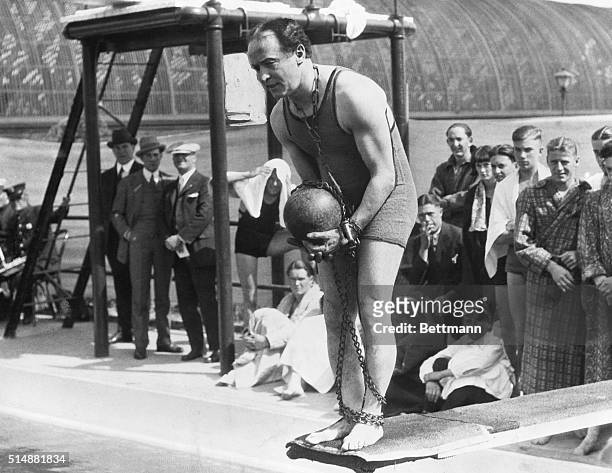 Portrait of famous escape artist Harry Houdini on diving board with ball and chain.