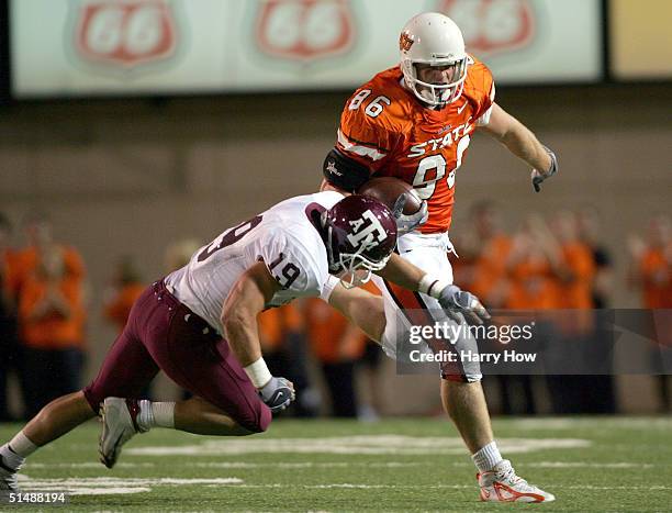 Billy Bajema of Oklahoma State runs over Jaxson Appel of Texas A & M in the second quarter at Boone Pickens Stadium on October 16, 2004 in...