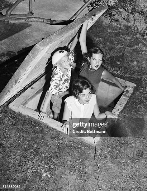 Ten-year-old Mitchell Legler , his sister Sandra , and her friend, Nancy Walker , test the escape hatch of the Legler family's bomb shelter in...