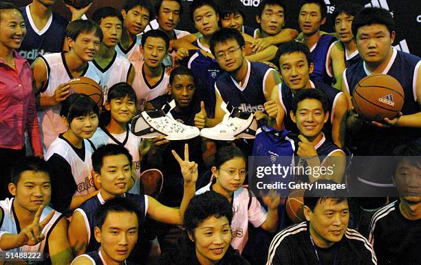 Tracy McGrady of the Houston Rockets poses with kids from the Beijing Union Special Education College October 16, 2004 in Beijing, China.