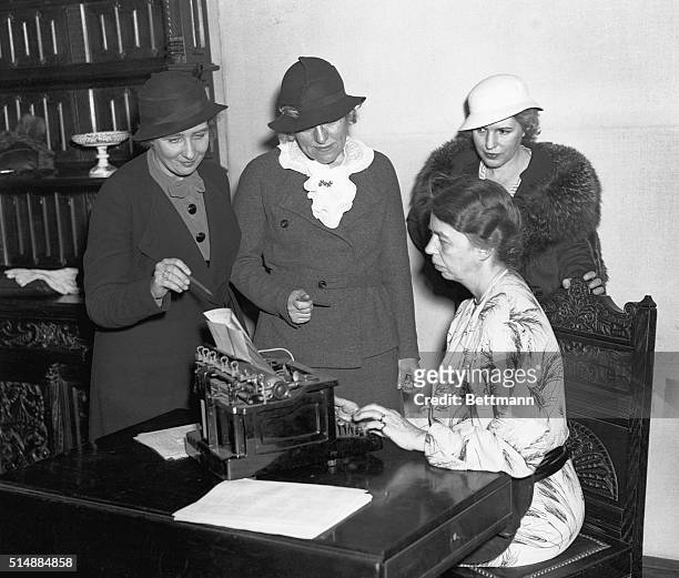 First Lady Eleanor Roosevelt types as newswomen watch. Gathered around the First Lady are Marjorie Shules, Emma Bugbee, and president of the...